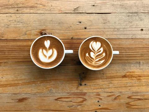 Tulip and rosetta pattern latte art of two cups of hot latte coffee Stock Photos