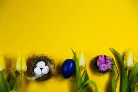 Tulips, Easter egg, Easter basket on yellow background Stock Photos