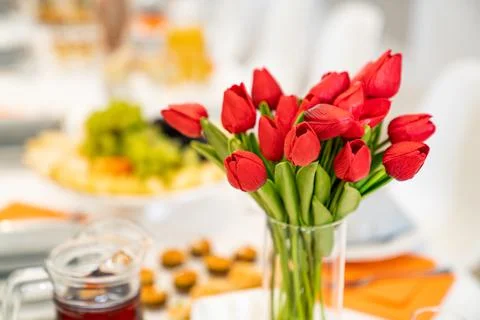 Tulips on festive table. serving table with appetizers, canapes, salads in jars Stock Photos