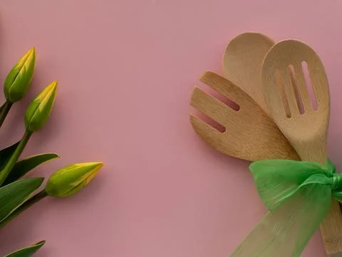 Tulips flowers with kitchen tools on background with copy space Stock Photos