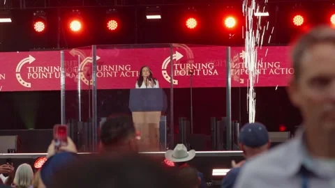 Tulsi Gabbard at the lectern as pyrotechnics fire at the Charlie Kirk memorial Stock Footage 345298222