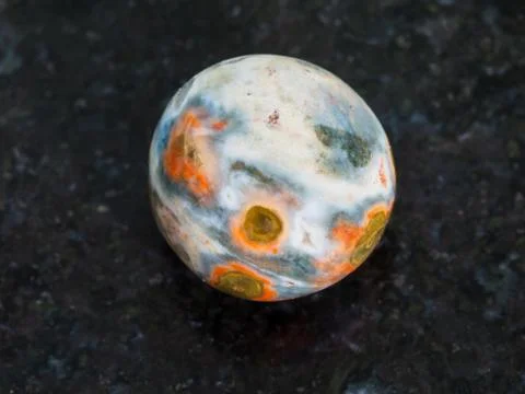 Tumbled orbicular jasper gemstone on dark Stock Photos