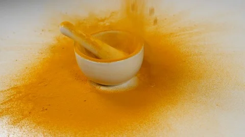 Tumeric curry powder in slow motion   in a white ceramic mortar and pestle  a Stock Footage 88517756