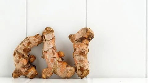 Tumeric (Turmeric) root with cut slice and green leaf isolated on white bac.. Stock Photos