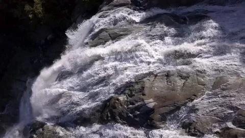 Tumultuous streams of water fall from a height, forming a waterfall Stock Footage 97083702