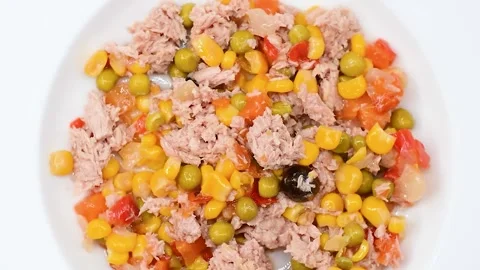 Tuna salad with corn, peas, carrots and olives on white plate, Close-up, Stock Footage 342190080