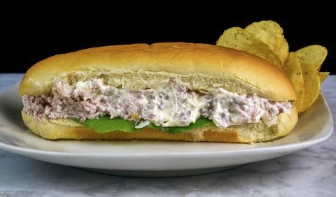 Tuna sub served with  a side of potato chips Stock Photos