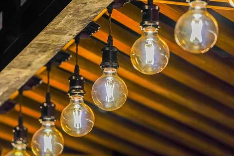 Tungsten circle lamp light on the row, stick on the wood kiosk ceiling. Stock Photos