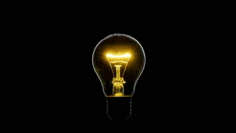 Tungsten light bulb blinking over black background, macro shot Stock Footage