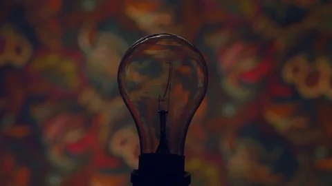 Tungsten light bulb lamp blinking against wall Stock Footage 103784091