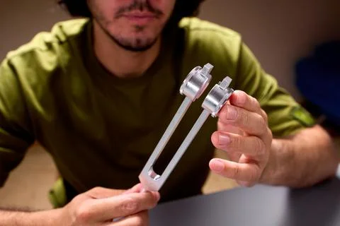 A tuning fork placed on the head demonstrates a detailed study of the perception Stock Photos