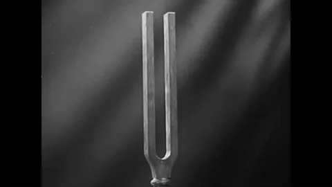 A tuning fork is shown as well as an animation showing sound waves and air Stock Footage