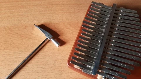 Tuning the kalimba tone with a small hammer, thumb piano Stock Footage 284326331