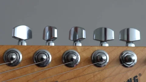 Tuning the strings of an electric guitar Stock Footage 333389943