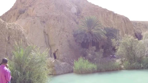 Tunisia man jumping into water between rocks Stock Footage 54924911