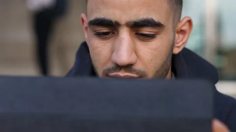 A tunisian male using a tablet computer in the city Stock Footage 218585683