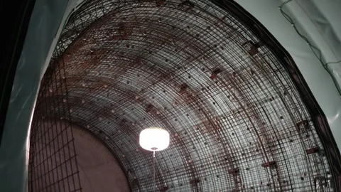 Tunnel ceiling lined with dense steel rebar grid under bright site light green w Stock Footage 309666340
