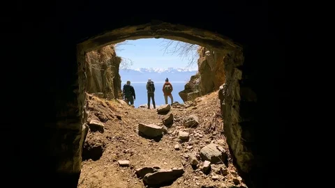 Tunnel gap viewpoint hiker with backpack standing on edge rock looking at baikal Stock Footage 123085731