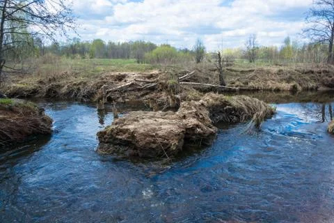The turbulent flow of a small river eroding banks. 스톡 사진