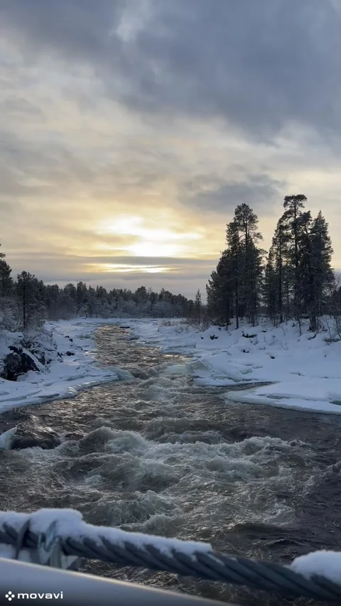 A turbulent mountain river flows between snow-covered banks. Stock Footage 303850529