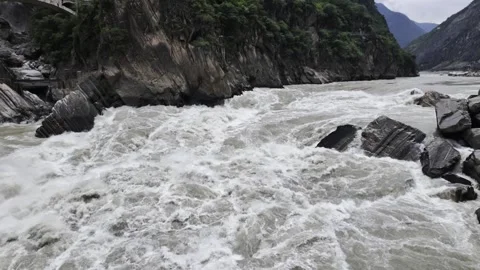 Turbulent River in Gorge with Arch Bridge and Rock Boulders Stock Footage 340130260