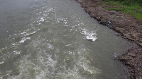 Turbulent white foam rapids rushing downstream along a rocky Stock Footage 342477397