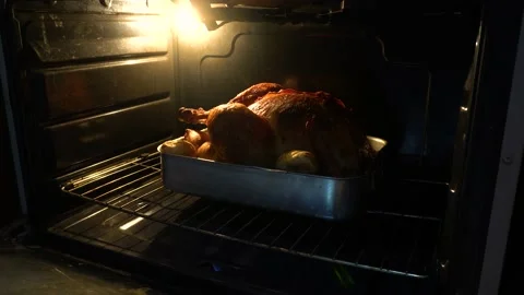 A turkey cooking in an oven. testing with a fork if it is already cooked Video stock 146019633