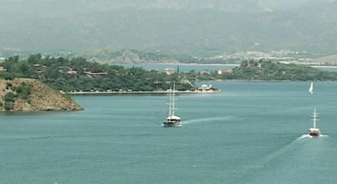 Turkey, Fethiye, 2009 Two yachts sail along bay along elongated peninsula. Stock Footage 159135341