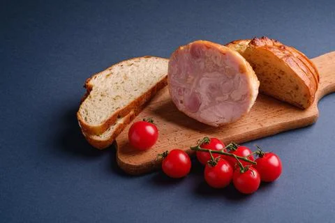 Turkey ham meat, fresh cherry tomatoes branch and loaf sliced bread on wood.. Stock Photos