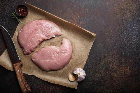Turkey lean raw fillet on baking paper with rosemary, garlic and spices Foto stock