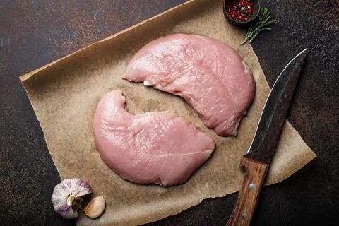 Turkey lean raw fillet on baking paper with rosemary, garlic and spices Stock Photos
