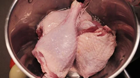 Turkey legs in a large pot covered with water, the process of making turkey soup Video stock 329997026