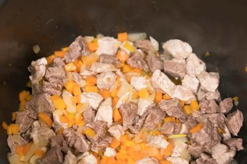Turkey meat is cooked in a pan. Beef, onion, carrot Stock Photos