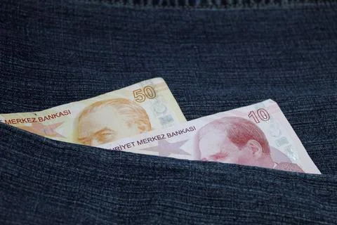 Turkish banknotes of different denomination between blue denim fabric Foto stock