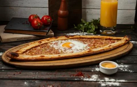 Turkish breakfast pide flatbread topped with minced meat and egg Stock Photos