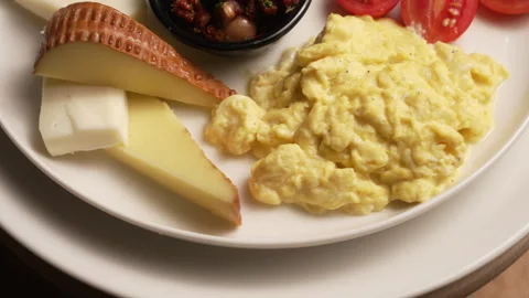 Turkish breakfast plate with assorted cheeses, scrambled eggs Stock Footage 333584224