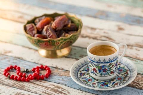 Turkish coffee, dates, and red rosary on turquoise table side view Stock Photos