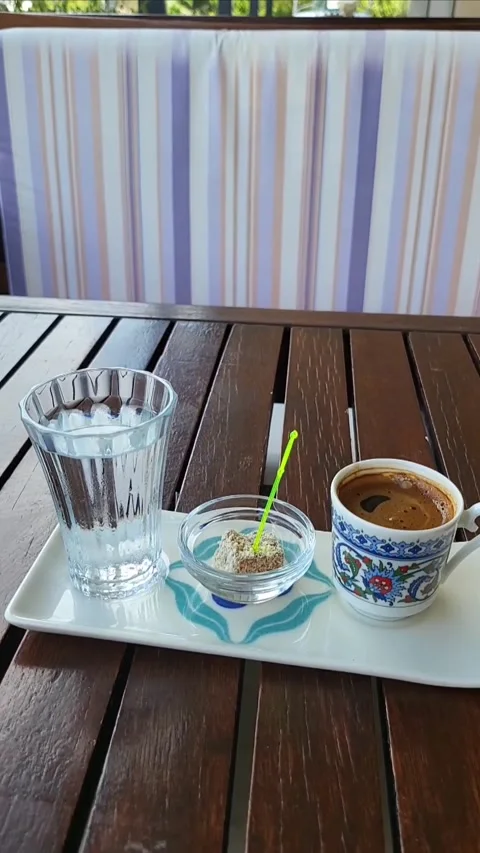 Turkish coffee served in patterned cup with glass of water and small dish with T Stock Footage 308728200