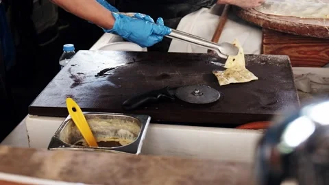 Turkish cook serving gozleme flatbread pieces to the tourists in restaurant Stock Footage 149377275
