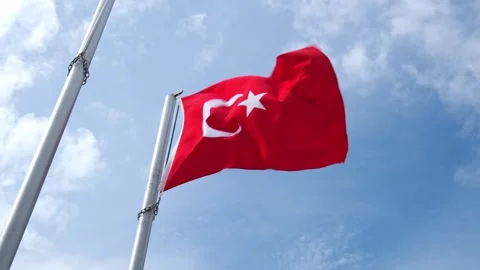 Turkish flag on flagpole flutters in wind against blue sky 스톡 동영상 316812908