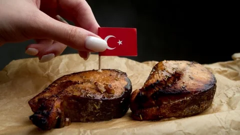 Turkish flag stuck into fish steak, symbol of local Turkish coastal fisheries. Stock Footage 323013111