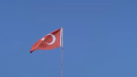 The Turkish flag waves against a clear blue sky, symbolizing national pride and Stock Footage 270084959