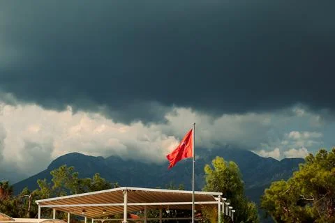 Turkish flag waves under dark clouds in a stormy sky near mountains in Turkey Stock-Fotos