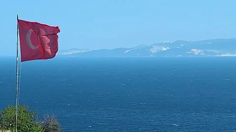 The Turkish Flag Waves with a View of Marmara Island and the Deep Blue Sea Stock Footage 322993067