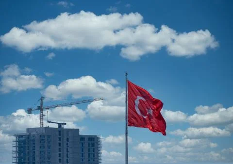 Turkish Flag waving front of Construction Crane and Clouds. Stock Photos