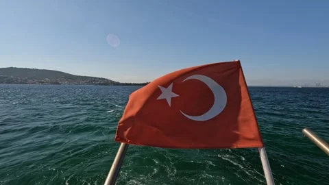 Turkish Flag Waving Over Clear Waters with Scenic Island in the Background Stock Footage 297877752
