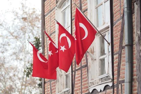 Turkish flags fly outside a building in daytime Stock Photos