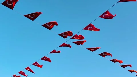Turkish Flags Hung on Diagonal Wires Against a Clear, Vivid Blue Sky Stock Footage 322997838