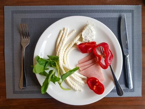 Turkish Helix String white Cheese with vegetables on plate with wooden back.. Stock Photos