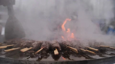 Turkish kebab is cooked on a circular grill in the open air. Stock-Footage 229556605